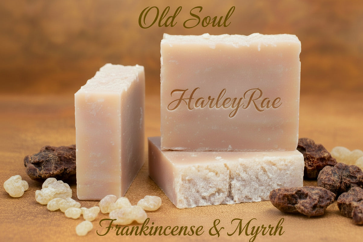 Three bars of HarleyRae soap with frankincense and myrrh on a wooden surface.