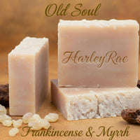 Three bars of HarleyRae soap with frankincense and myrrh on a wooden surface.