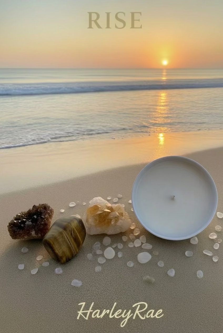 A white candle with clear liquid and citrine crystals on top, placed in a white bowl, with a wooden block and loose citrine crystals to the side, all set against a white fuzzy background.
